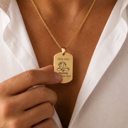 Gold necklace with a pendant on a person wearing a white shirt.